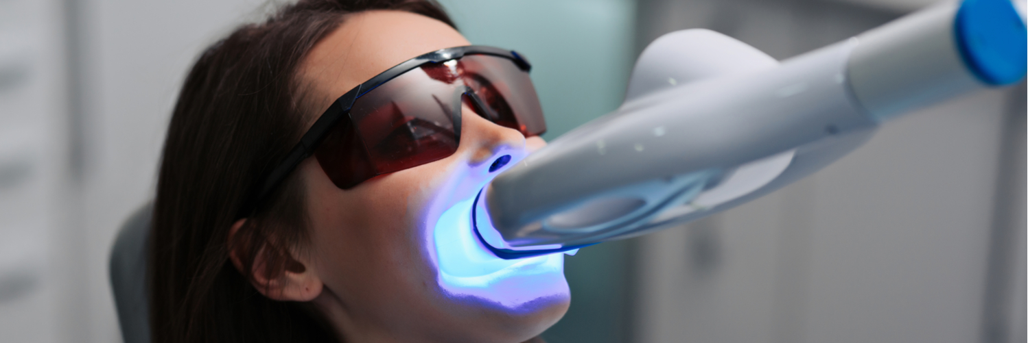 woman getting her teeth whitened with a laser - Saratoga Family Dentistry